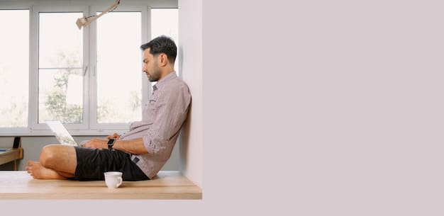 A person working at a laptop in a bright, modern home office. The background is blurred, showing a comfortable living space.