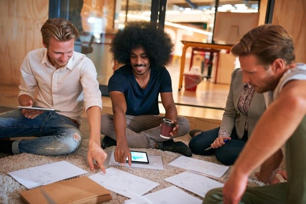 A diverse group of city planners and engineers collaborating around a table, reviewing smart city project blueprints and digital interfaces on laptops and tablets.