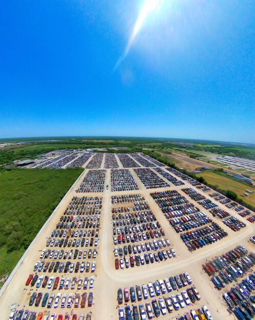 An aerial view of a newly constructed electric vehicle charging station along a major highway, showcasing solar panels providing renewable energy and multiple vehicles charging efficiently.