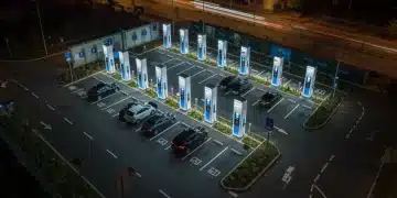 Modern EV charging station at night, multiple cars charging, universal connectors visible.
